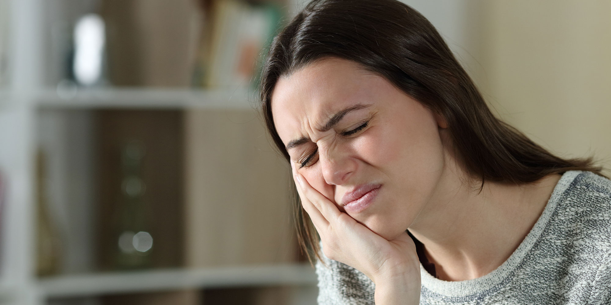person having minor mouth pain in their home