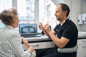 Senior patient consulting with Dr. Joon Park about dental implants in Fullerton CA